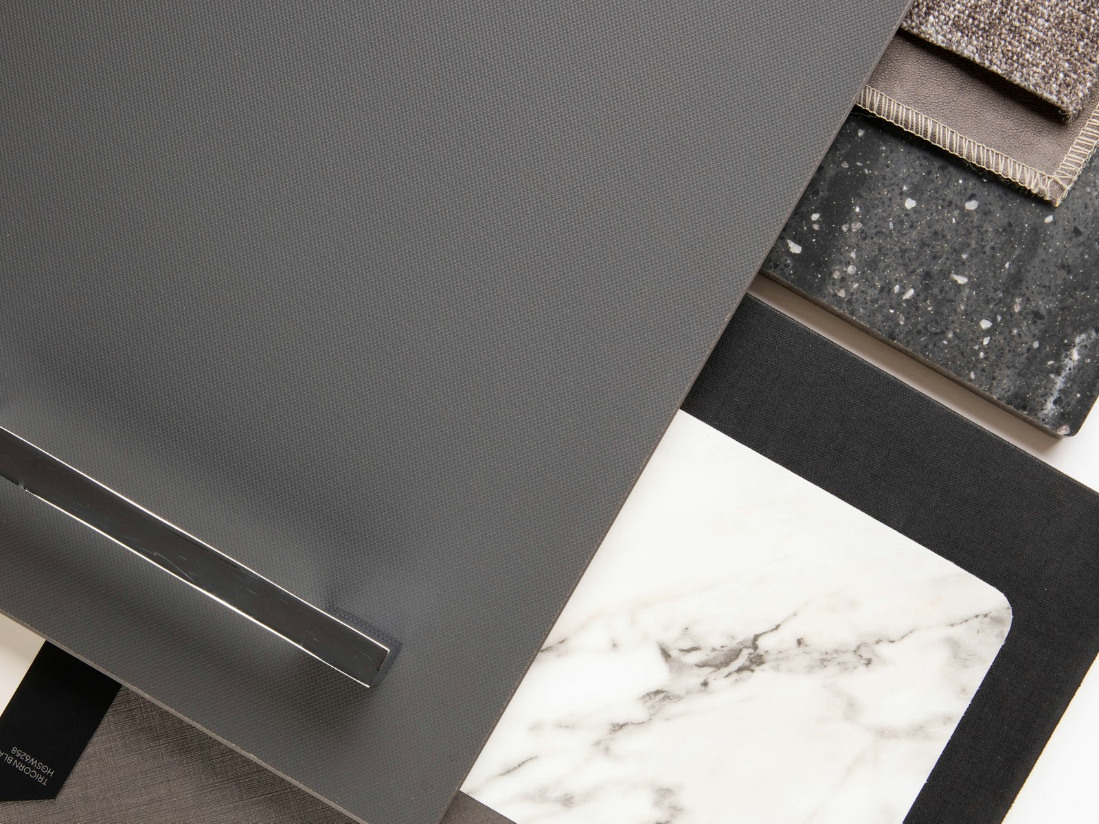 Stone, metal and marble finish samples on a white table
