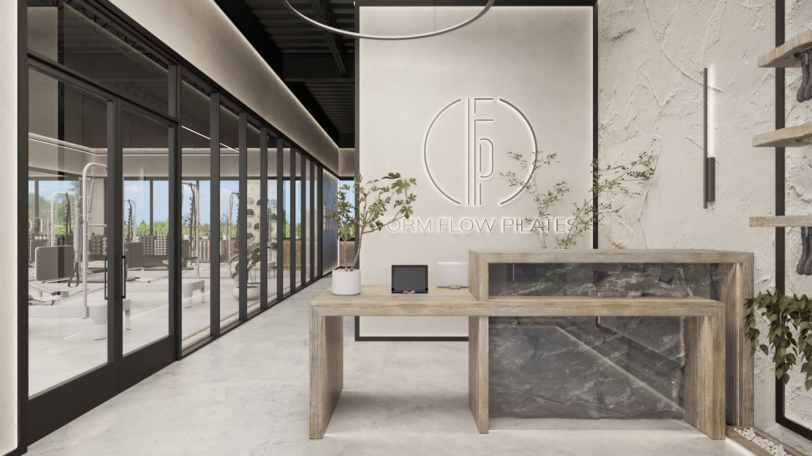 Form Flow Pilates, reception desk in stone and timber with a glazed studio beyond