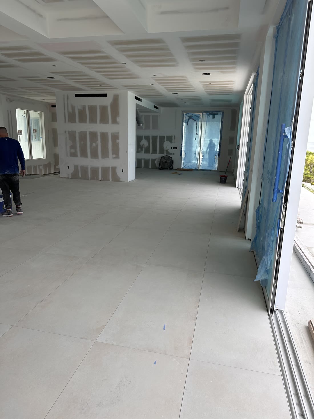The long view through the main floor under construction, coffered ceiling and tile in, openings cut for the sliding doors
